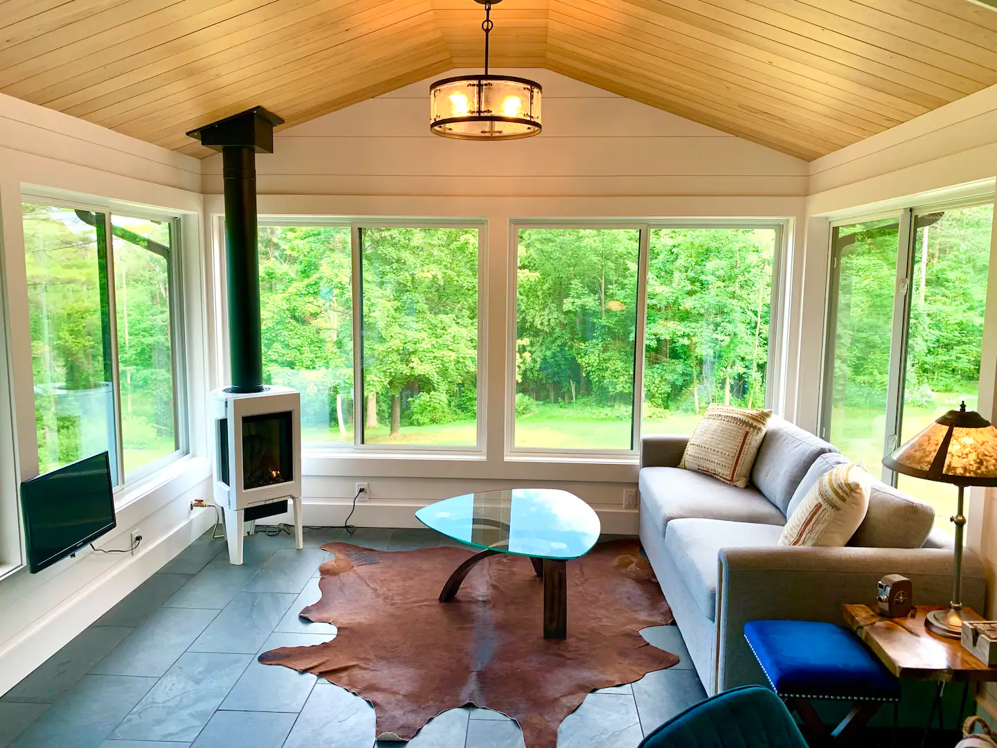 Sunroom seating surrounded by wooded views