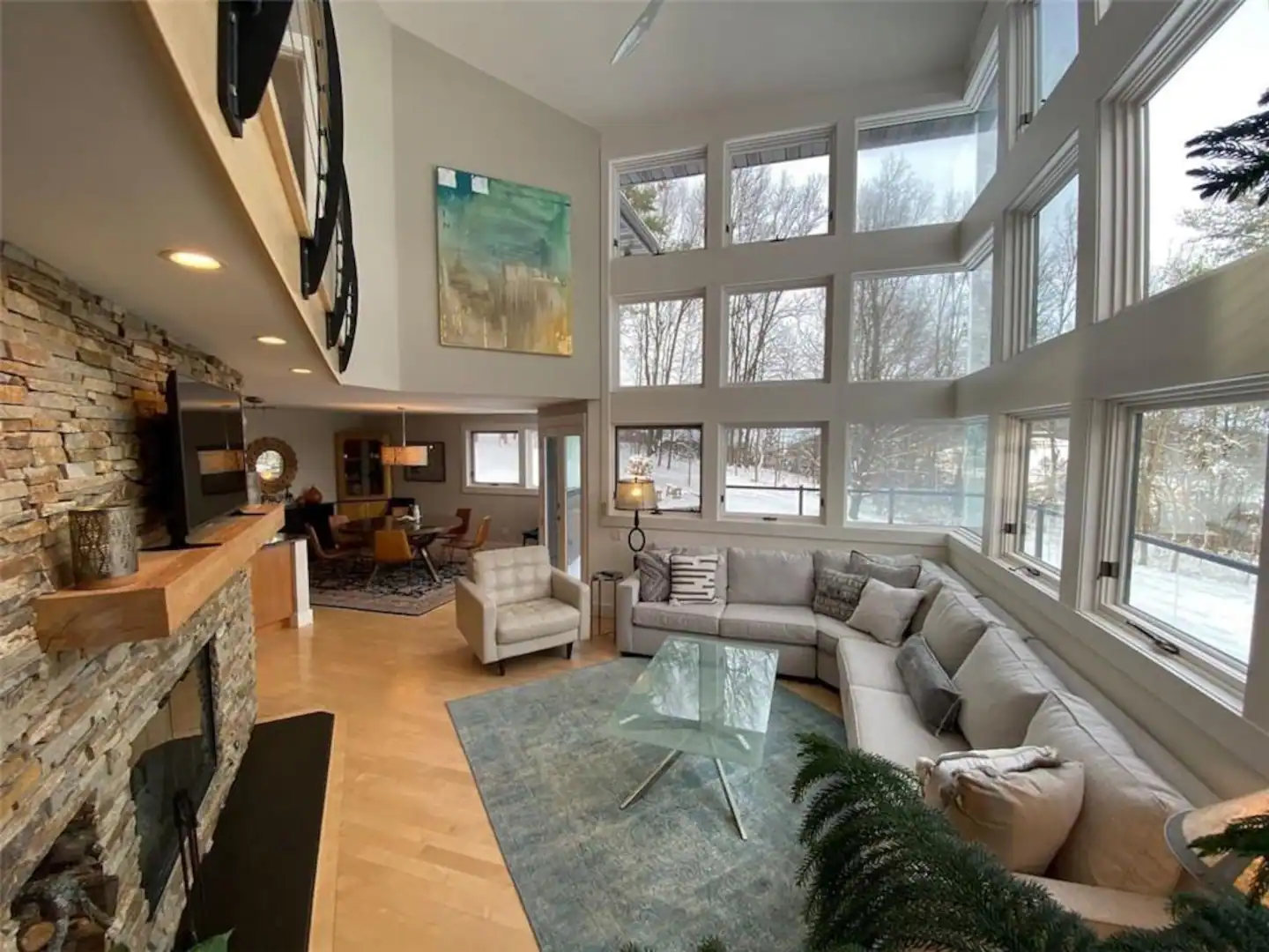 Living room with tall windows and a stone fireplace